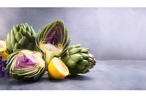 Fresh artichokes and lemon on a concrete surface – natural ingredients that support liver function during a spring detox.