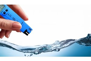 Hand holding a digital TDS meter measuring water quality – TDS testing for pure drinking water at Meditech Europe