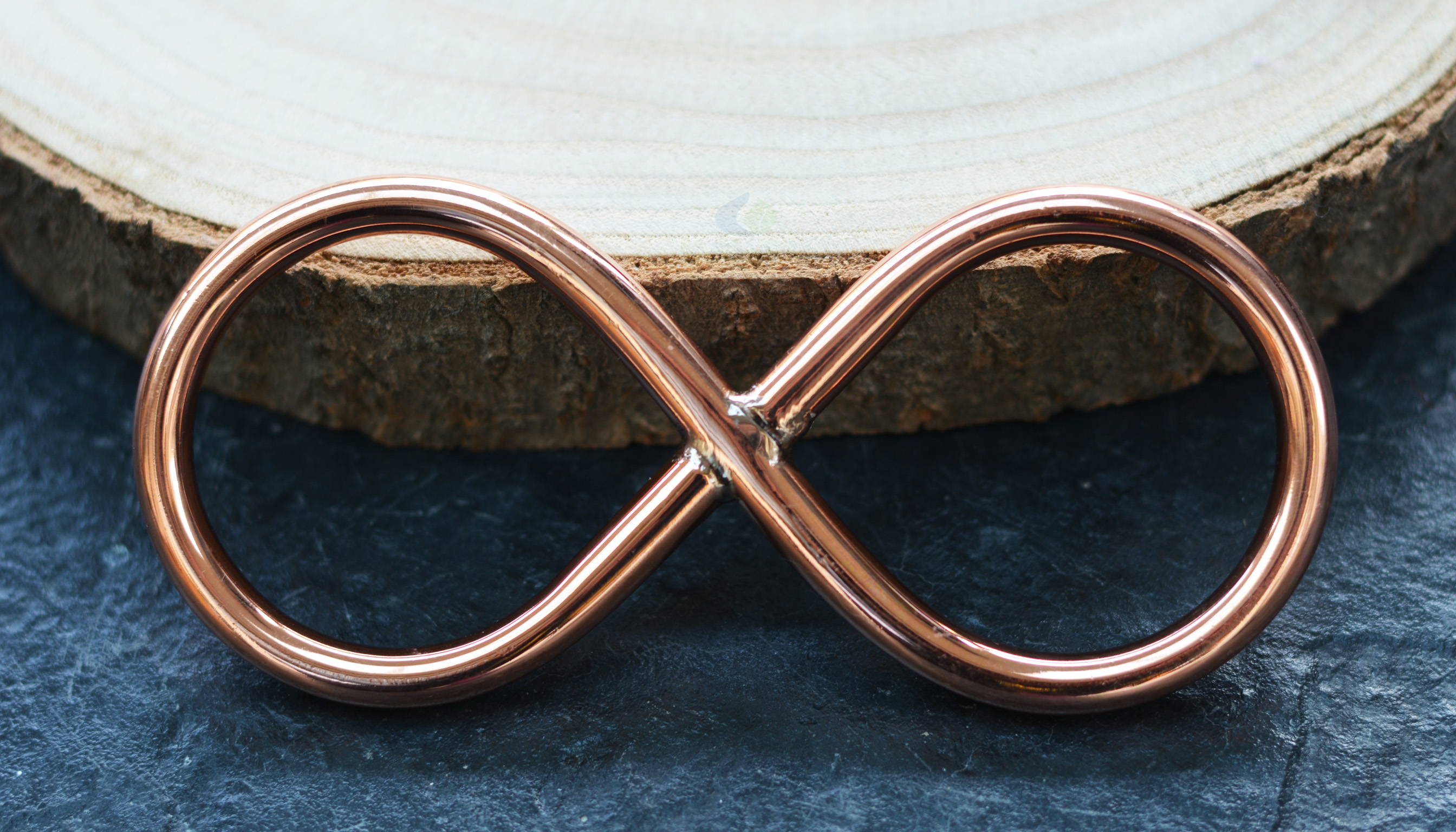 Copper lemniscate on wooden surface – Feng Shui decor for balance in the home.